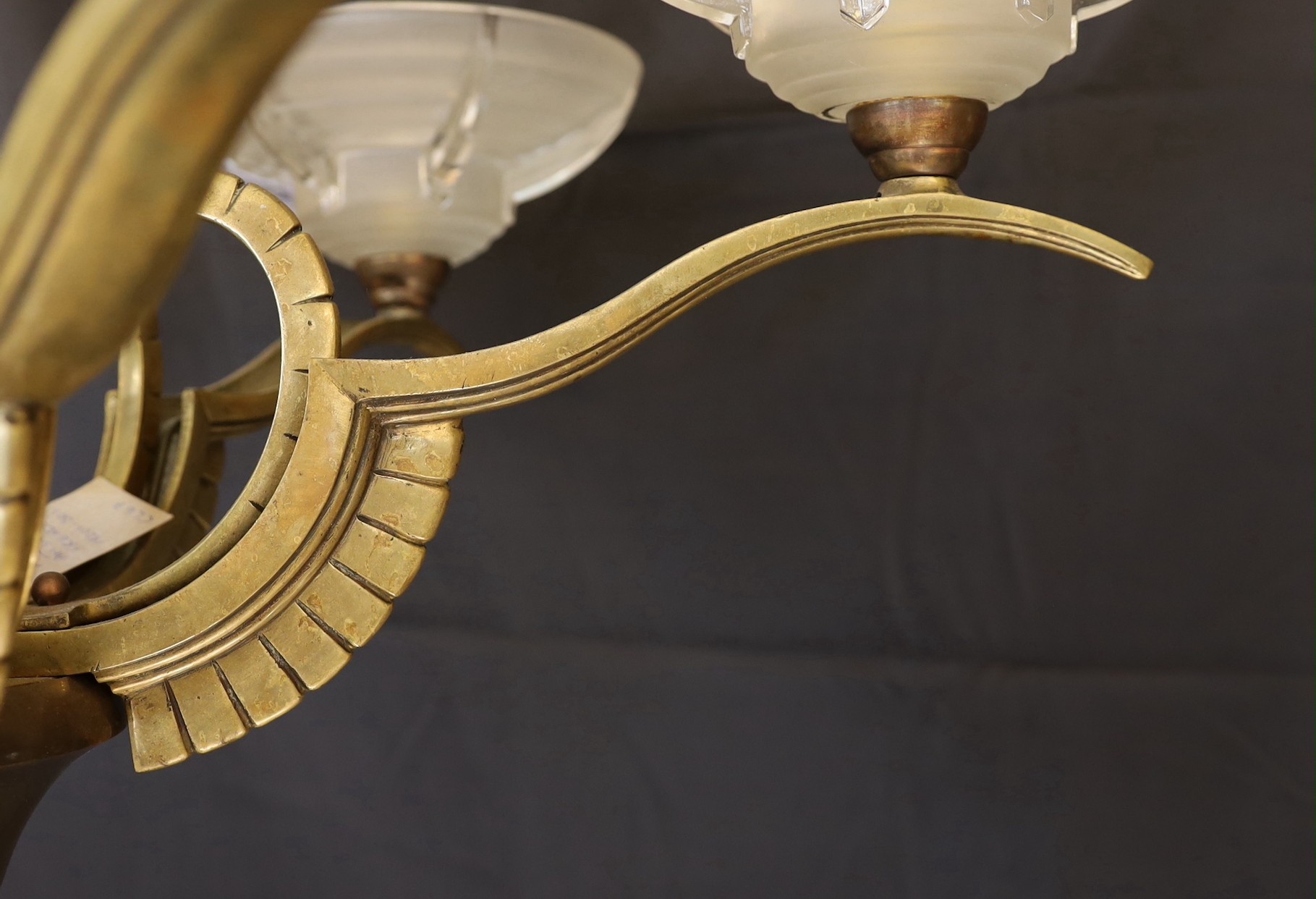 A French Art Deco bronze, hardwood and frosted glass six light chandelier, in the manner of Henri Petitot, height 64cm. width 74cm